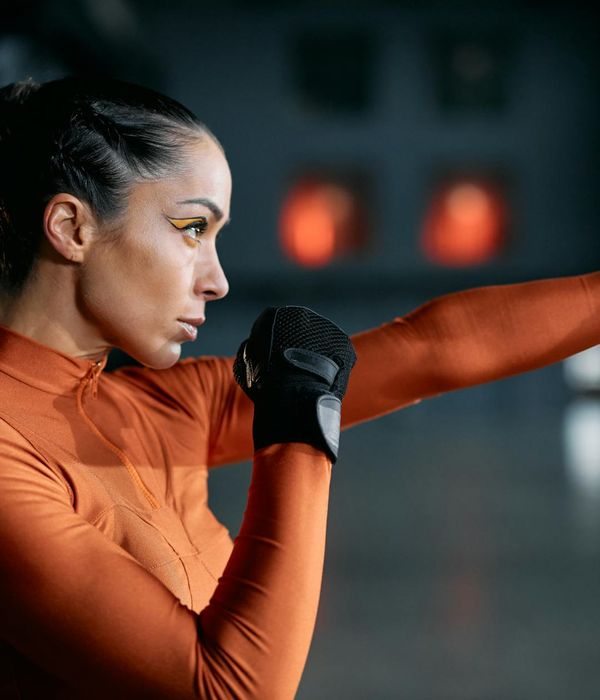 Woman performing a dynamic cardio exercise indoors.